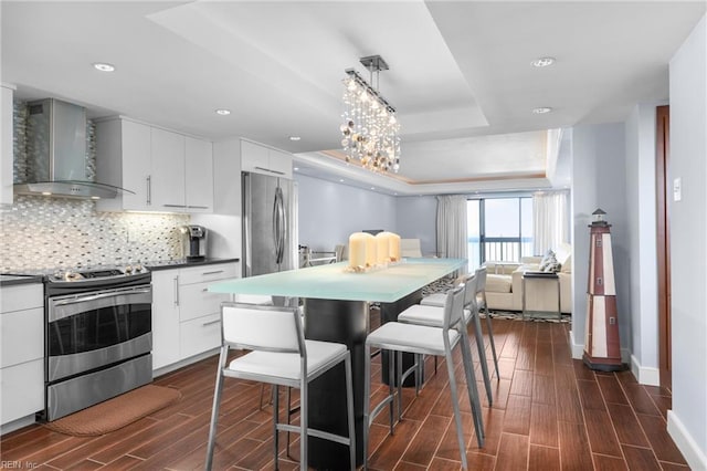 2830 Shore Dr Unit 1006, Virginia Beach, VA 23451 - kitchen featuring appliances with stainless steel finishes, wall chimney exhaust hood, baseboards, dark wood-style flooring, and dark countertops