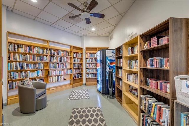 2830 Shore Dr Unit 1006, Virginia Beach, VA 23451 - living area featuring wall of books, ceiling fan, and a paneled ceiling