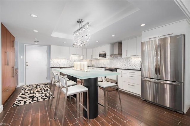 2830 Shore Dr Unit 1006, Virginia Beach, VA 23451 - kitchen with stainless steel appliances, a tray ceiling, wall chimney exhaust hood, dark wood-type flooring, and recessed lighting