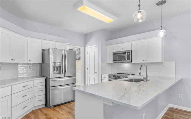 2129 Bierce Dr, Virginia Beach, VA 23454 - kitchen with appliances with stainless steel finishes, a sink, a peninsula, white cabinets, and light stone counters