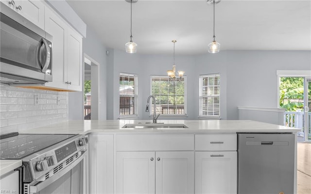 2129 Bierce Dr, Virginia Beach, VA 23454 - kitchen featuring appliances with stainless steel finishes, a sink, tasteful backsplash, white cabinets, and a chandelier