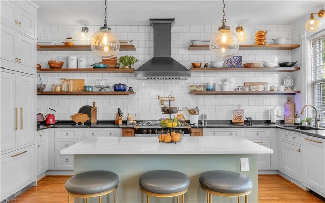 5312 Studeley Ave, Norfolk, VA 23508 - kitchen featuring open shelves, wall chimney exhaust hood, a sink, and a kitchen breakfast bar