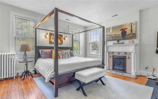 5312 Studeley Ave, Norfolk, VA 23508 - bedroom with radiator, hardwood / wood-style flooring, a tiled fireplace, and baseboards