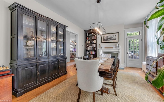 5312 Studeley Ave, Norfolk, VA 23508 - dining area featuring a chandelier, a fireplace, and light wood-style flooring