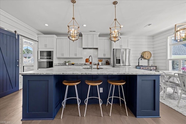 909 Los Colonis Dr, Virginia Beach, VA 23456 - kitchen featuring appliances with stainless steel finishes, a sink, a large island, white cabinets, and backsplash