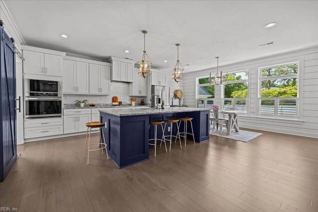 909 Los Colonis Dr, Virginia Beach, VA 23456 - kitchen with appliances with stainless steel finishes, plenty of natural light, a breakfast bar, white cabinetry, and recessed lighting
