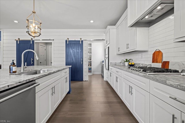909 Los Colonis Dr, Virginia Beach, VA 23456 - kitchen with stainless steel appliances, a barn door, a sink, wall chimney range hood, and white cabinets
