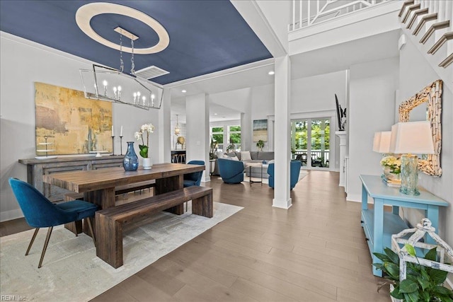 909 Los Colonis Dr, Virginia Beach, VA 23456 - dining space featuring a towering ceiling, wood finished floors, a chandelier, baseboards, and stairway