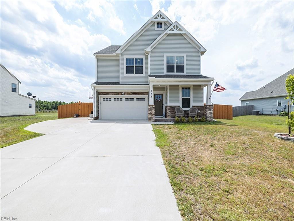 127 Mill Run Loop, South Mills, NC 27976 - craftsman-style home featuring an attached garage, driveway, covered porch, cooling unit, and stone siding