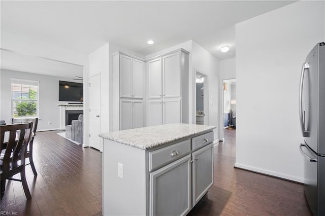 637 Wood Nymph Ln, Chesapeake, VA 23323 - kitchen featuring freestanding refrigerator, dark wood-style floors, a fireplace, gray cabinets, and open floor plan
