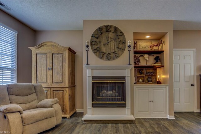 1808 Kensal Green Dr, Virginia Beach, VA 23456 - living room with dark wood-style floors, a textured ceiling, a fireplace with raised hearth, and baseboards