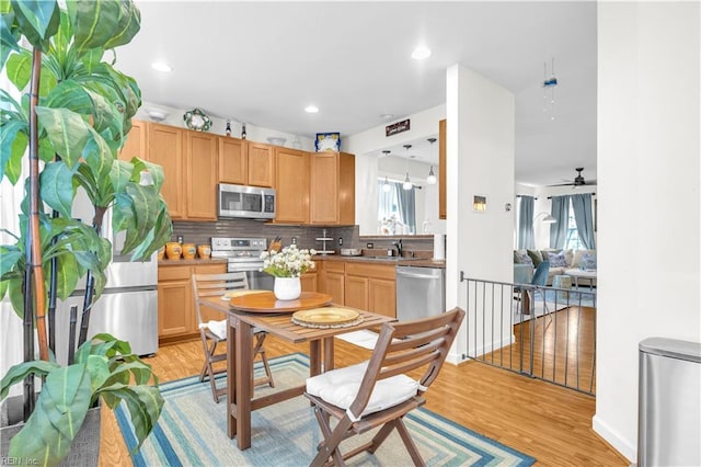 245 Feldspar St, Virginia Beach, VA 23462 - kitchen featuring appliances with stainless steel finishes, backsplash, light wood-type flooring, a sink, and a ceiling fan