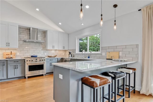 808 High Point Ave, Virginia Beach, VA 23451 - kitchen with wall chimney exhaust hood, high end range, vaulted ceiling, gray cabinets, and backsplash