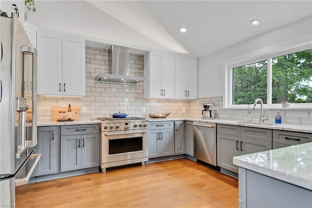 808 High Point Ave, Virginia Beach, VA 23451 - kitchen with premium appliances, wall chimney exhaust hood, gray cabinetry, a sink, and vaulted ceiling