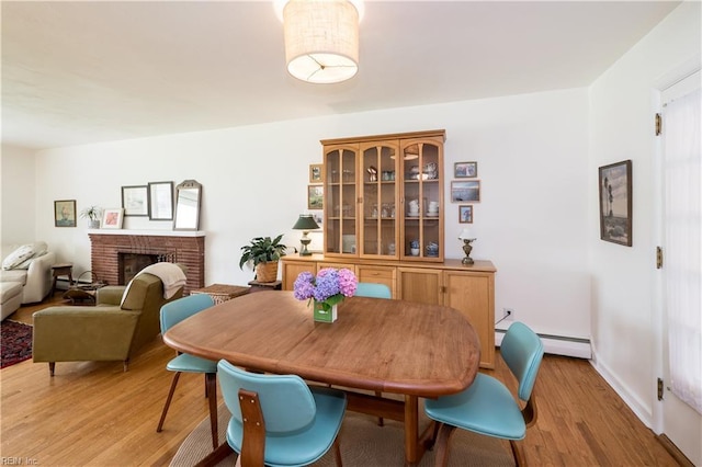 2522 Jasper Ct, Norfolk, VA 23518 - dining area with light wood finished floors, a brick fireplace, and a baseboard heating unit