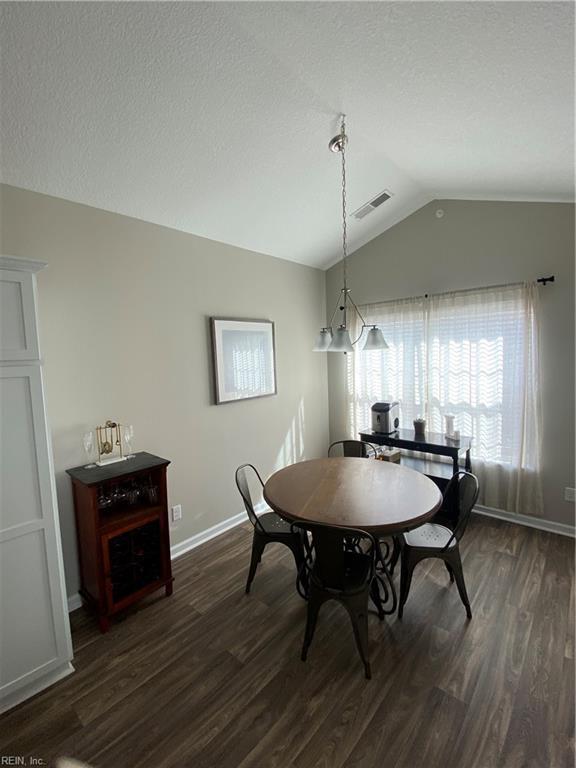 1010 Kings Land Ct, Williamsburg, VA 23185 - dining room featuring lofted ceiling and dark wood-style flooring