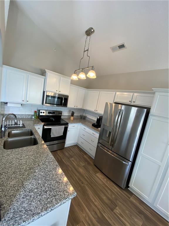 1010 Kings Land Ct, Williamsburg, VA 23185 - kitchen with appliances with stainless steel finishes, white cabinetry, decorative backsplash, dark wood-style floors, and high vaulted ceiling