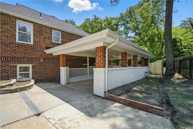 5133 E Princess Anne Rd, Norfolk, VA 23502 - view of home's exterior with brick siding, a patio area, and roof with shingles