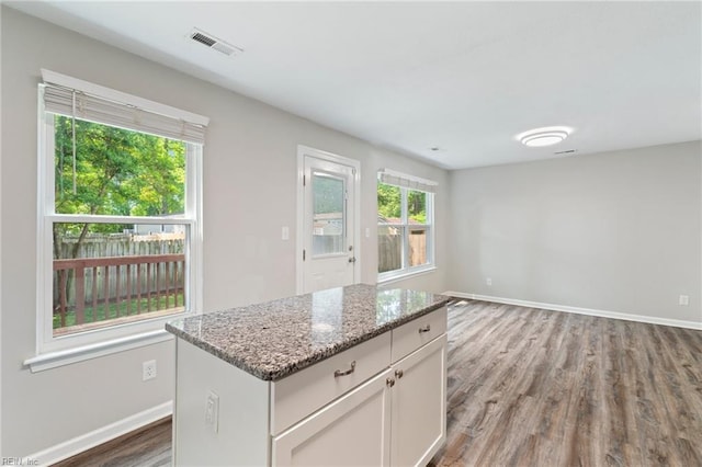 230 Abingdon Cir, Suffolk, VA 23434 - kitchen with wood finished floors, baseboards, light stone counters, and a center island