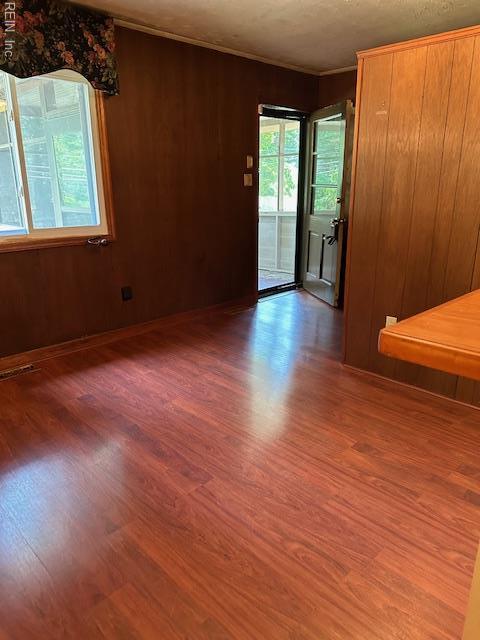 5216 Hemlock Rd, Quinton, VA 23141 - spare room featuring wood finished floors, wooden walls, and ornamental molding