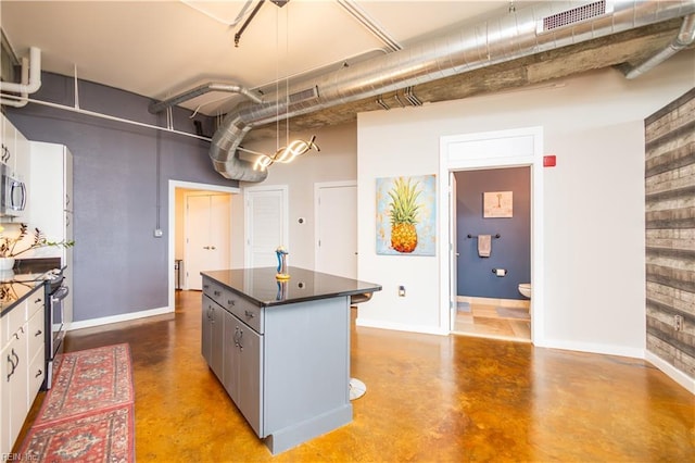 415 Saint Pauls Blvd Unit 702, Norfolk, VA 23510 - kitchen with finished concrete flooring, stainless steel appliances, dark countertops, a kitchen island, and a towering ceiling