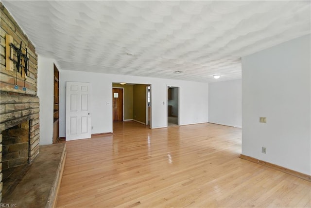 3555 Heutte Dr, Norfolk, VA 23518 - unfurnished living room with a brick fireplace, light wood-type flooring, and baseboards