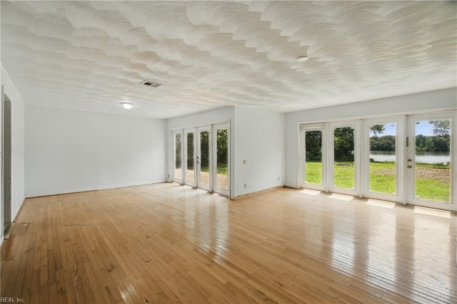3555 Heutte Dr, Norfolk, VA 23518 - empty room with a water view, light wood-style flooring, and baseboards