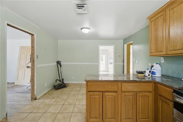 3555 Heutte Dr, Norfolk, VA 23518 - kitchen with a peninsula, brown cabinetry, and light tile patterned floors