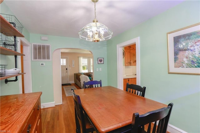 327 Brightwood Ave, Hampton, VA 23661 - dining area with arched walkways, a chandelier, wood finished floors, and baseboards