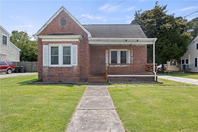 1040 Poquoson Ave, Poquoson, VA 23662 - bungalow-style house featuring covered porch, brick siding, a shingled roof, and central AC