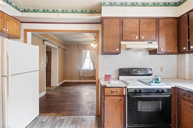 1040 Poquoson Ave, Poquoson, VA 23662 - kitchen with electric range, under cabinet range hood, freestanding refrigerator, light wood-style floors, and light countertops