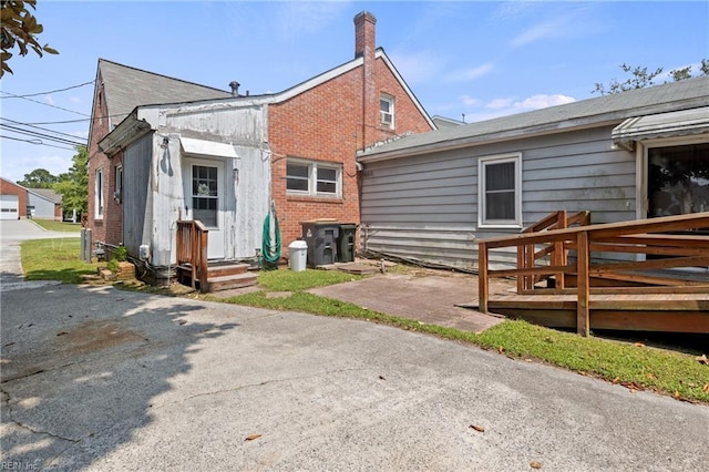 1040 Poquoson Ave, Poquoson, VA 23662 - back of property featuring brick siding, a chimney, and a wooden deck