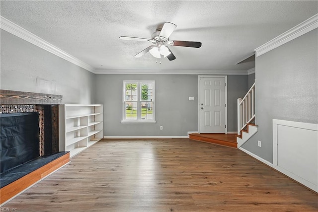 915 Spinnaker Ct, Chesapeake, VA 23320 - unfurnished living room featuring a fireplace with raised hearth, wood finished floors, a ceiling fan, crown molding, and a textured ceiling