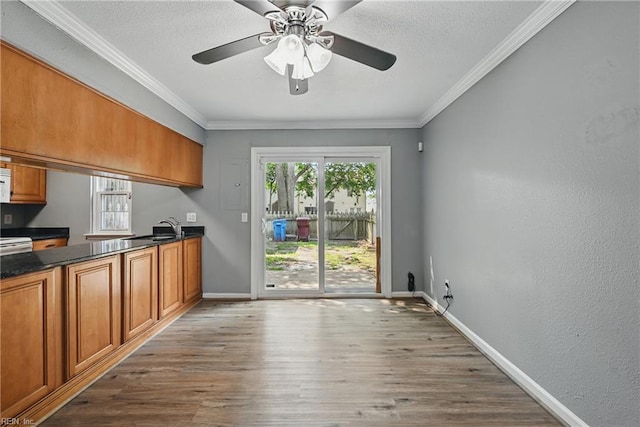 915 Spinnaker Ct, Chesapeake, VA 23320 - kitchen featuring brown cabinets, wood finished floors, baseboards, a sink, and crown molding