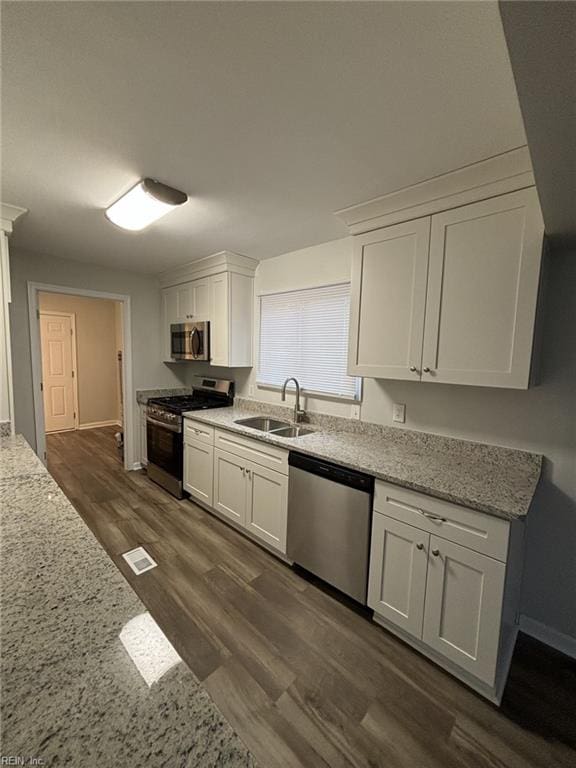 711 Vellines Ave, Chesapeake, VA 23324 - kitchen with appliances with stainless steel finishes, a sink, white cabinetry, dark wood-type flooring, and baseboards