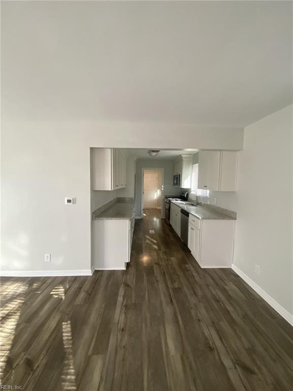 711 Vellines Ave, Chesapeake, VA 23324 - kitchen featuring dark wood-style floors, baseboards, dishwasher, a sink, and white cabinets