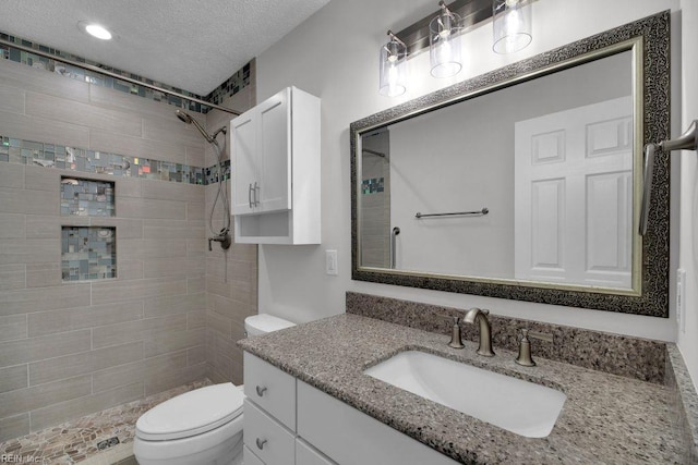 105 Londonderry Ln, Williamsburg, VA 23188 - bathroom featuring toilet, vanity, tiled shower, and a textured ceiling