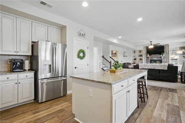 2685 Robert Monette Ln, Virginia Beach, VA 23456 - kitchen featuring stainless steel fridge, a ceiling fan, light wood finished floors, light stone counters, and a kitchen island