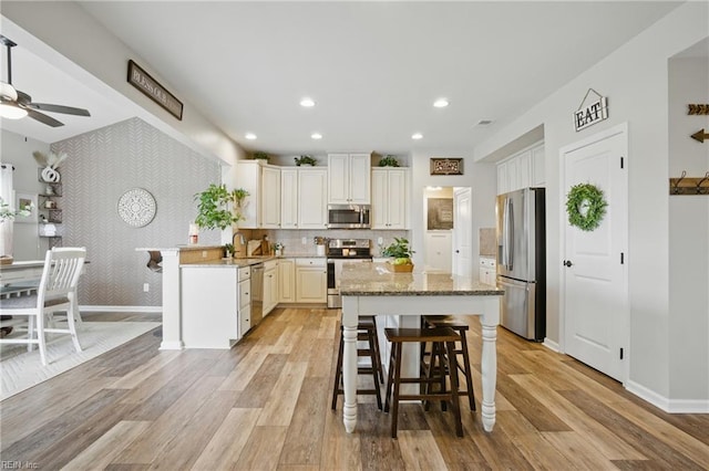 2685 Robert Monette Ln, Virginia Beach, VA 23456 - kitchen featuring appliances with stainless steel finishes, baseboards, a kitchen bar, light wood-style floors, and recessed lighting