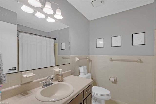 1 Smith St, Poquoson, VA 23662 - full bath featuring tile walls, toilet, vanity, a wainscoted wall, and a shower with curtain