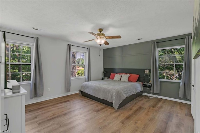 1 Smith St, Poquoson, VA 23662 - bedroom with multiple windows, light wood finished floors, a textured ceiling, and baseboards