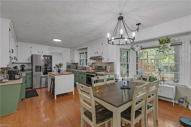 1 Smith St, Poquoson, VA 23662 - dining room with a chandelier, light wood-style flooring, and a textured ceiling