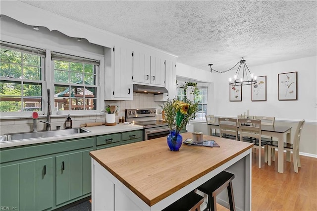 1 Smith St, Poquoson, VA 23662 - kitchen with electric range, green cabinets, a chandelier, a textured ceiling, and healthy amount of natural light