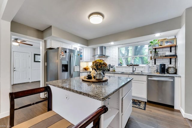 401 Kings Point Rd, Virginia Beach, VA 23452 - kitchen featuring appliances with stainless steel finishes, wall chimney exhaust hood, white cabinetry, and tasteful backsplash