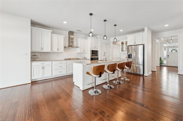 1652 Teton Ct, Chesapeake, VA 23320 - kitchen featuring wall chimney exhaust hood, stainless steel appliances, dark wood-style flooring, a breakfast bar area, and tasteful backsplash