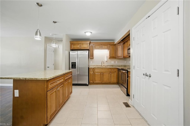 2613 Cedar Rd, Chesapeake, VA 23323 - kitchen featuring stainless steel appliances, a sink, brown cabinetry, light stone counters, and decorative light fixtures