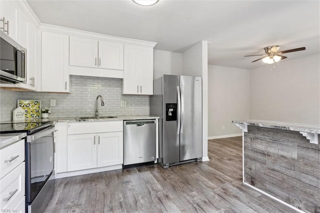 3054 Comte Ct, Virginia Beach, VA 23453 - kitchen featuring stainless steel appliances, a sink, ceiling fan, decorative backsplash, and wood finished floors
