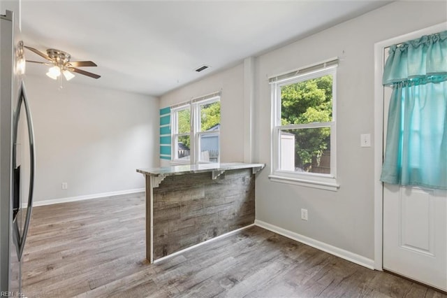 3054 Comte Ct, Virginia Beach, VA 23453 - kitchen featuring stainless steel refrigerator with ice dispenser, wood finished floors, baseboards, ceiling fan, and a kitchen bar