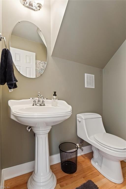 5891 Chaucer Dr, Providence Forge, VA 23140 - bathroom featuring toilet, wood finished floors, baseboards, vaulted ceiling, and a sink