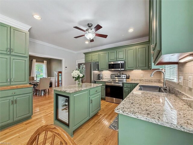5891 Chaucer Dr, Providence Forge, VA 23140 - kitchen with stainless steel appliances, green cabinetry, a sink, a center island, and ornamental molding